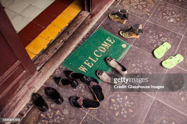 welcome mat and shoes at temple entrance, hanoi, vietnam - zerbino foto e immagini stock