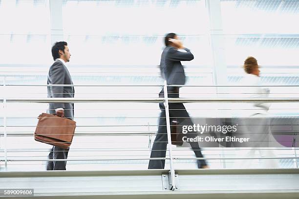 businesspeople walking on walkway - oliver eltinger stock-fotos und bilder