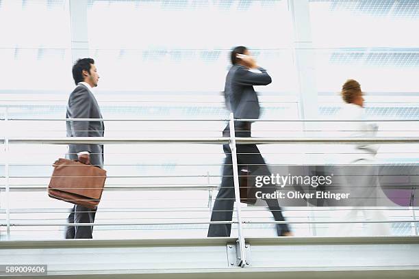 businesspeople walking on walkway - oliver eltinger stock pictures, royalty-free photos & images