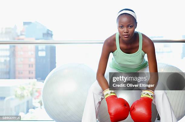 woman sitting on fitness ball wearing boxing gloves - oliver eltinger fotografías e imágenes de stock