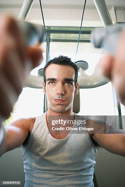 man using weight machine - oliver eltinger fotografías e imágenes de stock