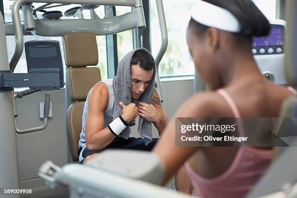 man and women using gym equipment - oliver eltinger stock pictures, royalty-free photos & images
