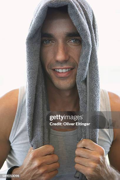 friendly man with towel on covering head - oliver eltinger stock pictures, royalty-free photos & images