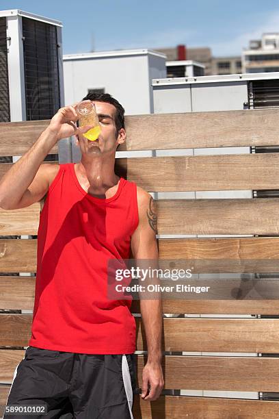 thirsty man drinking sports drink - oliver eltinger - fotografias e filmes do acervo