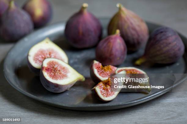 sliced and whole figs on plate - fig imagens e fotografias de stock