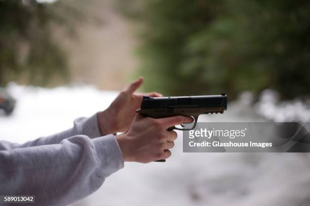 man aiming handgun, profile - revolver stock-fotos und bilder