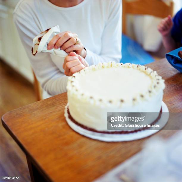 woman decorating a cake - decorating a cake fotografías e imágenes de stock