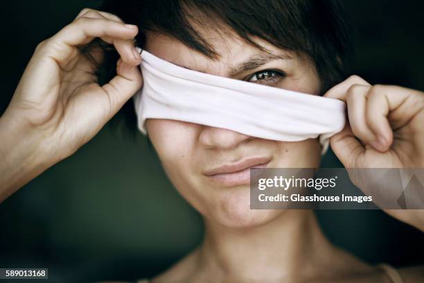 woman pulling blindfold from eyes - blindfold stock pictures, royalty-free photos & images