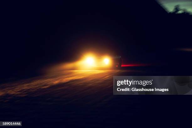car with headlights on at night - faro luz de vehículo fotografías e imágenes de stock