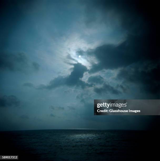 storm clearing up at sea - maanlicht stockfoto's en -beelden