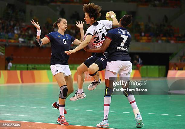 Han Na Gwon of Korea is challenged by Camille Ayglon Saurina of France and Allison Pineau of France during the Womens Preliminary Group B match...