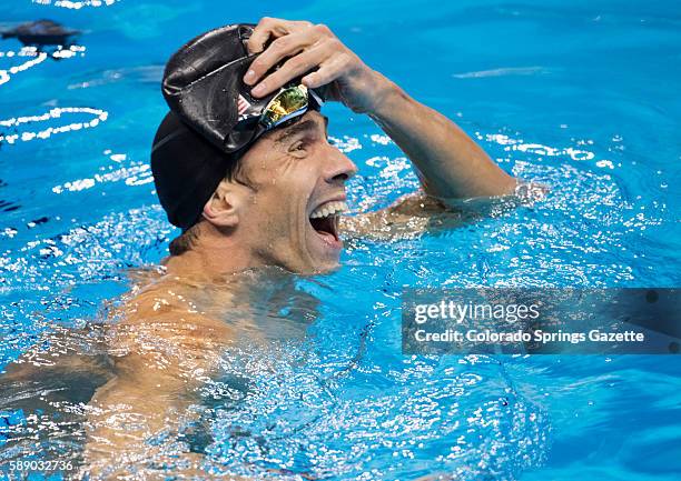 Swimmer Michael Phelps laughs after seeing results that show him in a three-way tie for second in the 100m Buttterfly at Olympic Aquatics Park in Rio...