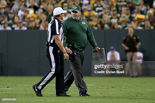 Head coach Mike McCarthy of the Green Bay Packers talks with official Mike Ed Hochuli in the second quarter against the Cleveland Browns at Lambeau...