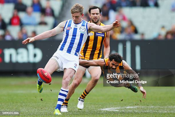 Cyril Rioli of the Hawks tackles Jack Ziebell of the Kangaroos as he kicks the ball during the round 21 AFL match between the Hawthorn Hawks and the...