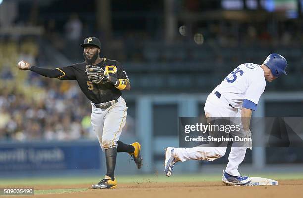 Second baseman Josh Harrison of the Pittsburgh Pirates throws to first after forcing out Chase Utley of the Los Angeles Dodgers but is too late to...