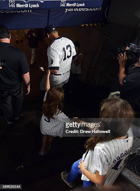 Alex Rodriguez of the New York Yankees walks into the clubhouse with his daughters Natasha and Ella after the game against the Tampa Bay Rays at...
