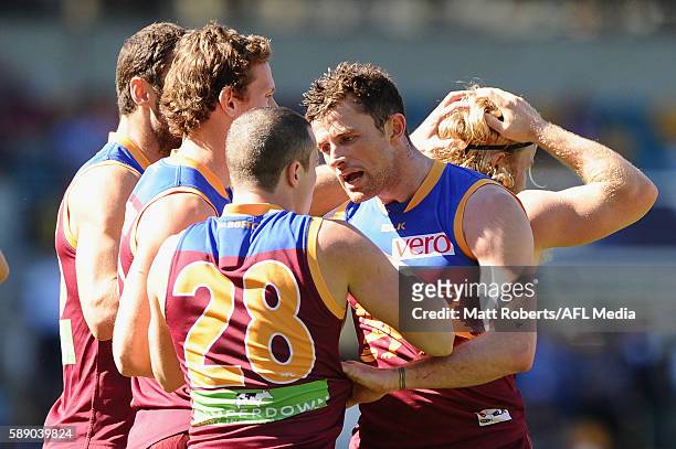 Pearce Hanley of the Lions speaks with Lewis Taylor after a goal by Daniel Rich during the round 21 AFL match between the Brisbane Lions and the...