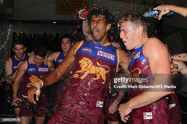 Archie Smith and Jarrad Jansen of the Lions celebrate victory with team mates after the round 21 AFL match between the Brisbane Lions and the Carlton...