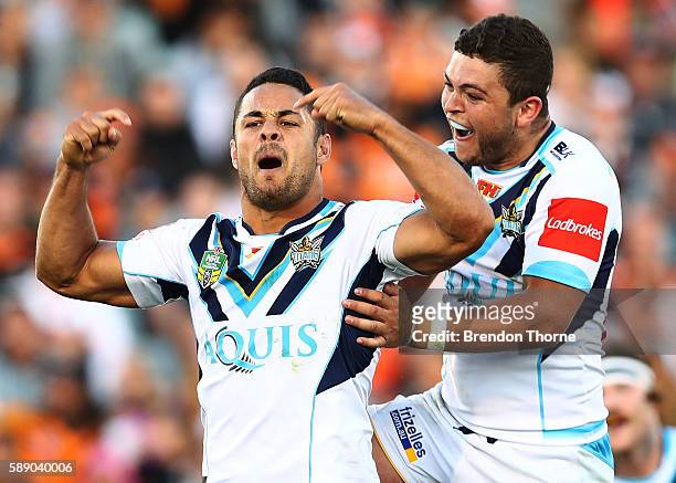 Jarryd Hayne of the Titans celebrates with team mate Ashley Taylor after kicking a drop goal to win the match during the round 23 NRL match between...