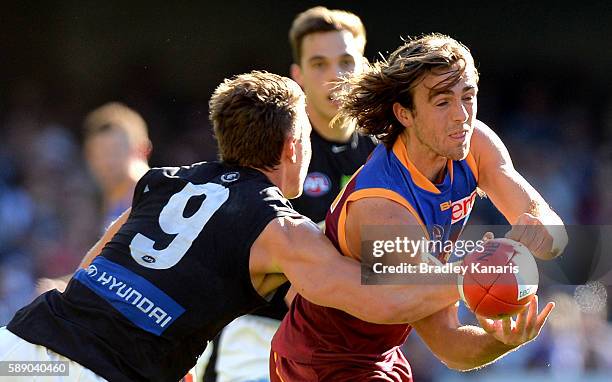 Rhys Mathieson of the Lions gets a handball away during the round 21 AFL match between the Brisbane Lions and the Carlton Blues at The Gabba on...