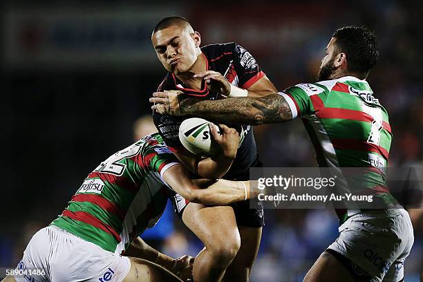 Tuimoala Lolohea of the Warriors charges into Adam Reynolds and Kyle Turner of the Rabbitohs during the round 23 NRL match between the New Zealand...