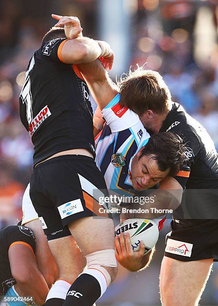 David Shillington of the Titans is tackled by the Tigers defence during the round 23 NRL match between the Wests Tigers and the Gold Coast Titans at...