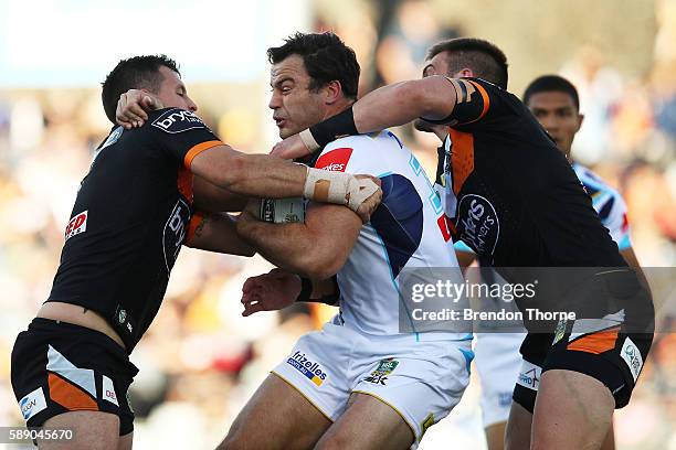 David Shillington of the Titans is tackled by Jackson Littlejohn of the Tigers during the round 23 NRL match between the Wests Tigers and the Gold...