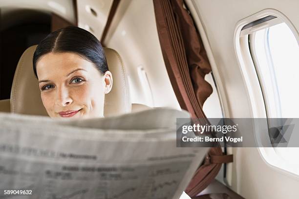 businesswoman on airplane - personal wealth stock pictures, royalty-free photos & images