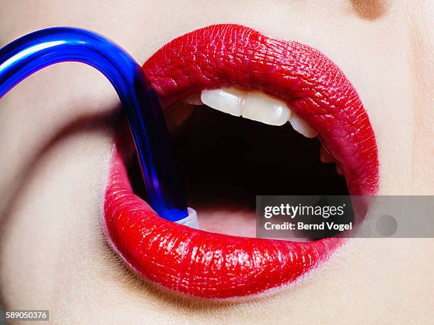 close-up shot of a woman's full red lips - straw lips stock pictures, royalty-free photos & images