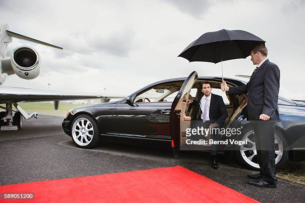 businessman exiting limousine on airport runway - luxury cars stock pictures, royalty-free photos & images