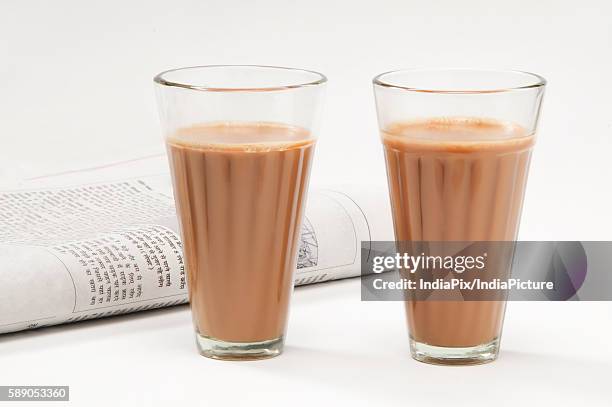 glasses of chai with newspaper isolated on white background - chai tea stock pictures, royalty-free photos & images