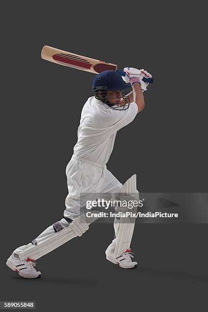 young male player playing cricket isolated over gray background - cricket player isolated stock pictures, royalty-free photos & images