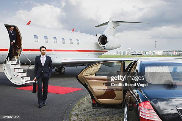businessman approaching car at airport - capitalismo foto e immagini stock