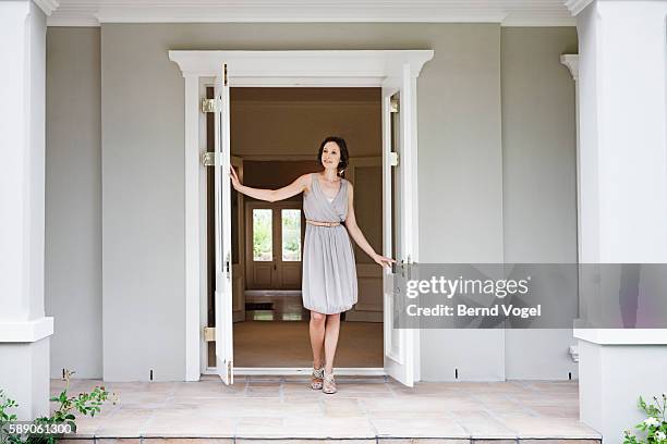 woman opening french doors - woman standing in doorway stock pictures, royalty-free photos & images