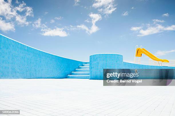 abandoned pool with yellow slide - swimming pool no people stock pictures, royalty-free photos & images