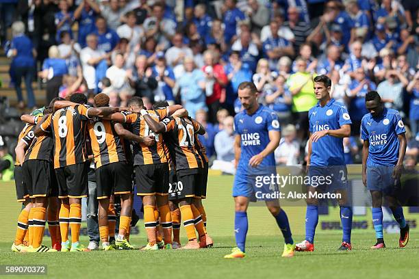 Hull City players create a huddle after the final whistle while the Leicester City players show dejection during the Premier League match between...