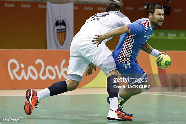 Croatia's right back Ivan Cupic vies with a French player during the men's preliminaries Group A handball match Croatia vs France for the Rio 2016...