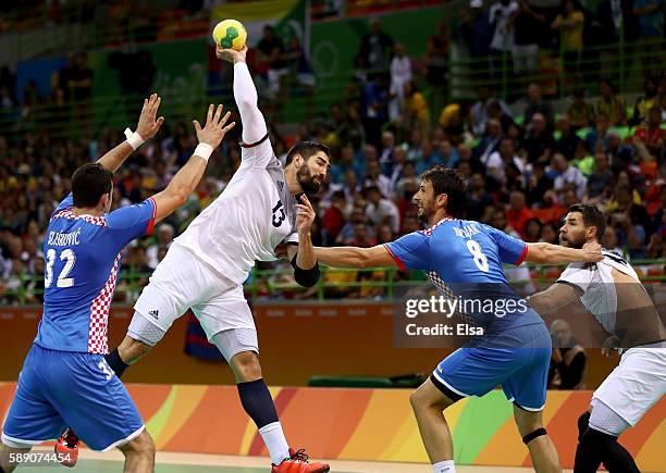 Nikola Karabatic of France is challenged by Ivan Sliskovic and Marko Kopljar of Croatia during the Men's Handball preliminary Group A match between...