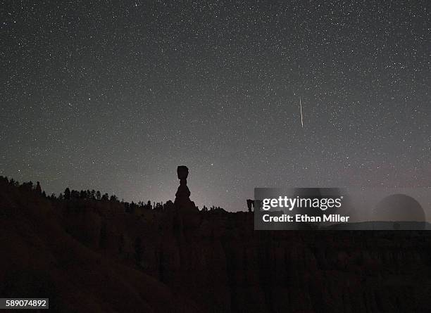 Perseid meteor streaks across the sky above the hoodoos named Thor's Hammer and the Three Sisters early on August 13, 2016 in Bryce Canyon National...