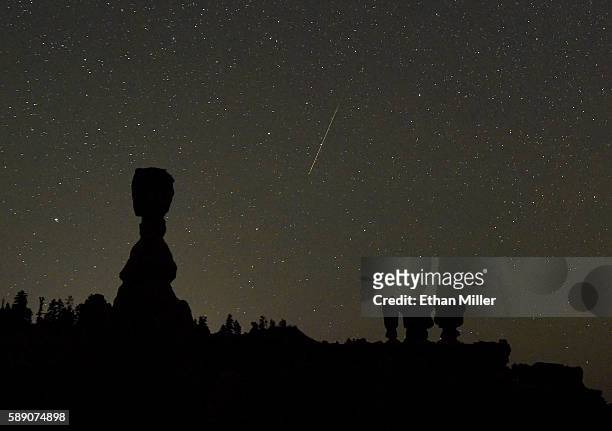 Perseid meteor streaks across the sky between the hoodoos named Thor's Hammer and the Three Sisters early on August 13, 2016 in Bryce Canyon National...