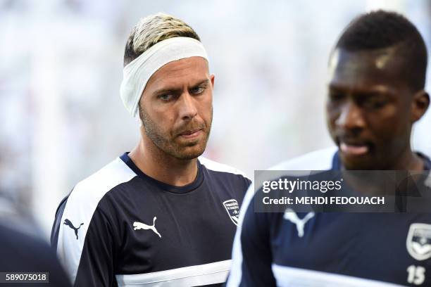 Bordeaux's player Jeremy Menez, wearing a bandage following an injury during his last match, warms up prior to the French L1 footbal match between...