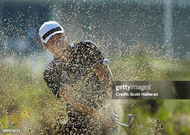Julien Quesne of France plays a shot from a waste area on the tenth hole during the third round of the golf on Day 8 of the Rio 2016 Olympic Games at...