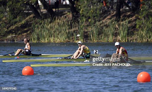 S Genevra Stone , Australia's Kimberley Brennan and China's Duan Jingli sit on their boats after the Women's Single Sculls final rowing competition...