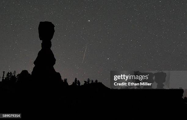 Perseid meteor streaks across the sky between the hoodoos named Thor's Hammer and the Three Sisters early on August 13, 2016 in Bryce Canyon National...