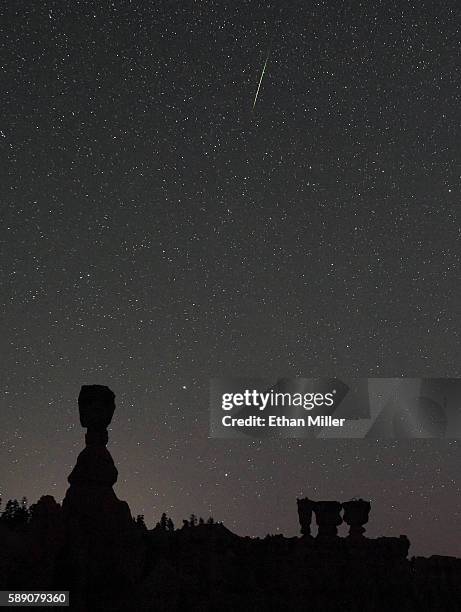 Perseid meteor streaks across the sky above the hoodoos named Thor's Hammer and the Three Sisters early on August 13, 2016 in Bryce Canyon National...