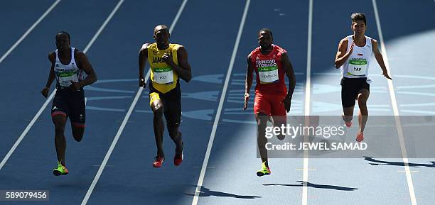 Britain's James Dasaolu, Jamaica's Usain Bolt, Trinidad and Tobago's Richard Thompson and Singapore's Yap Jin Wei Timothee compete in the Men's 100m...