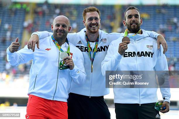 Silver medalist Piotr Malachowski of Poland, Gold medalist Christoph Harting of German and Bronze medalist Daniel Jasinski of Germany celebrate on...