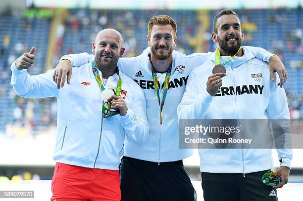 Silver medalist Piotr Malachowski of Poland, Gold medalist Christoph Harting of German and Bronze medalist Daniel Jasinski of Germany celebrate on...