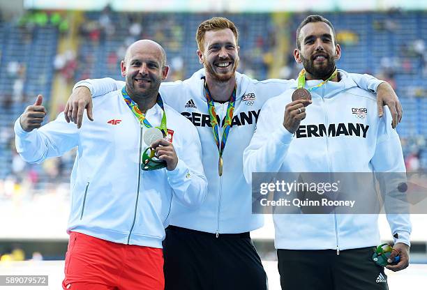 Silver medalist Piotr Malachowski of Poland, Gold medalist Christoph Harting of German and Bronze medalist Daniel Jasinski of Germany celebrate on...