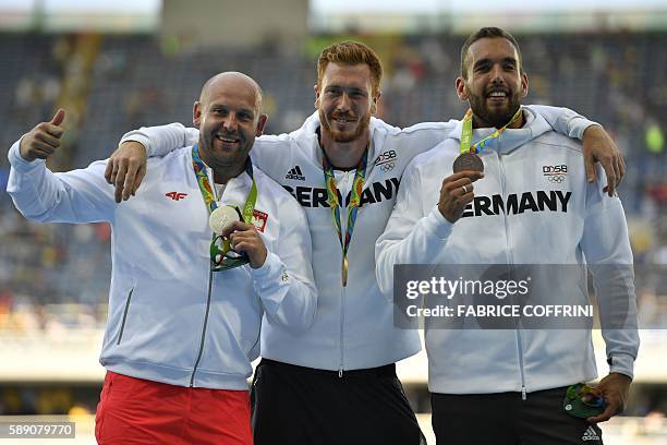 Silver medallist Poland's Piotr Malachowski, Gold medallist Germany's Christoph Harting, and bronze medallist Germany's Daniel Jasinski celebrate on...